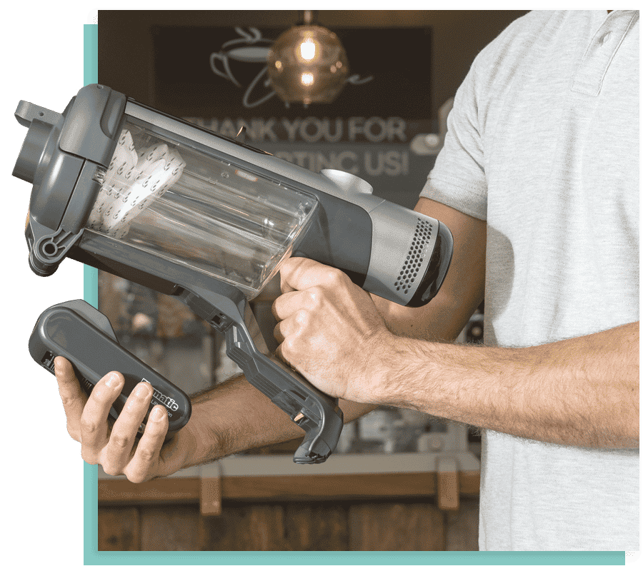 numatic quick homme met la batterie sur l'aspirateur à balai