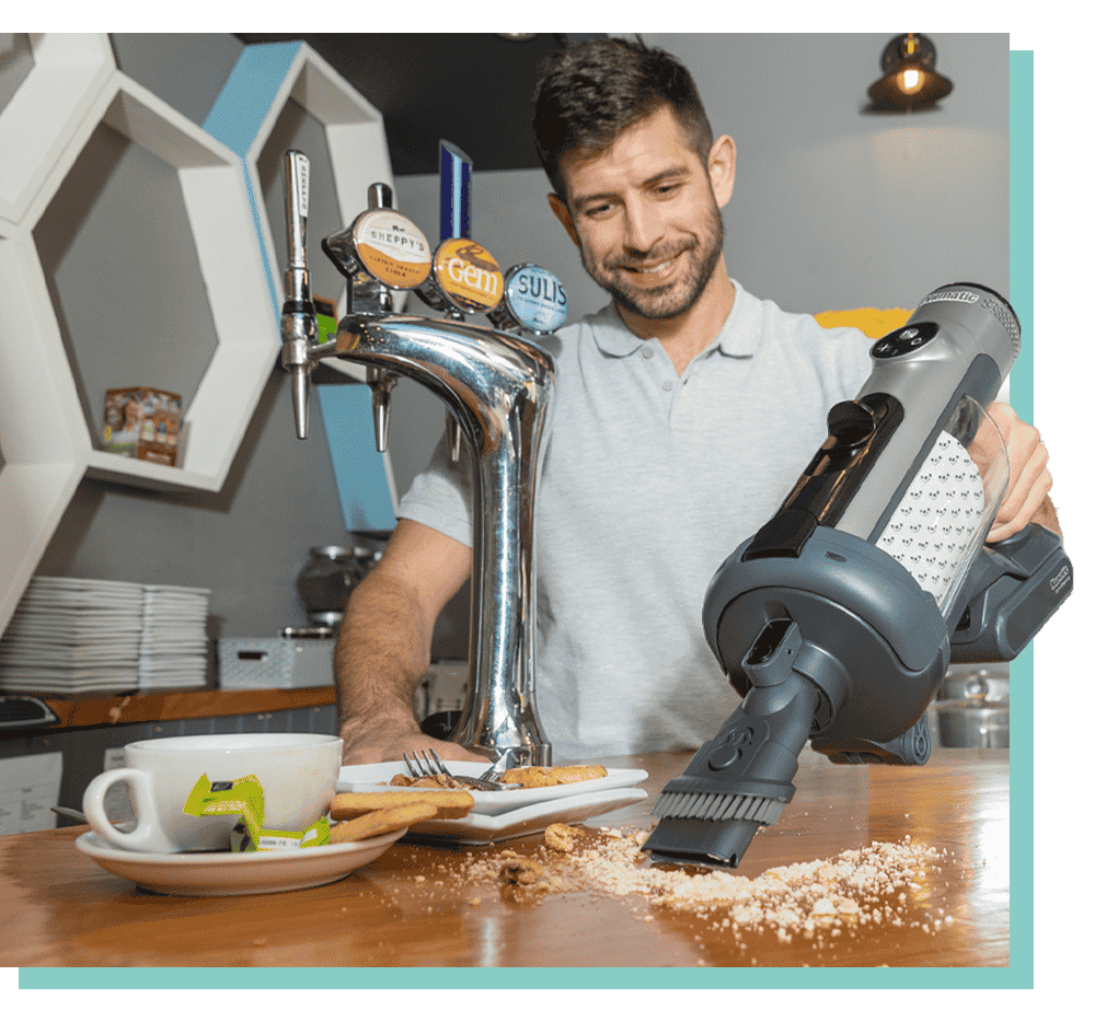numatic quick homme qui aspire sur une table